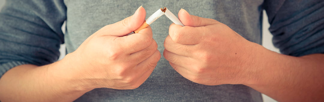 persona rompiendo un cigarro