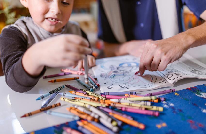 Niño utilizando ceras de colores