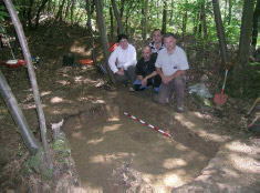 Descubridores de la fosa y familiares. Descubridores de la fosa y familiares. Detrás se observa el muro que delimita la trinchera.